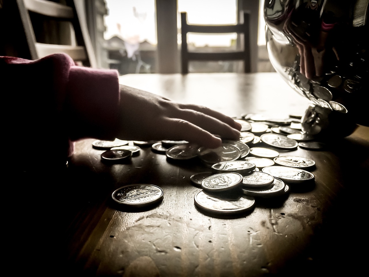 A person's hand handling coins