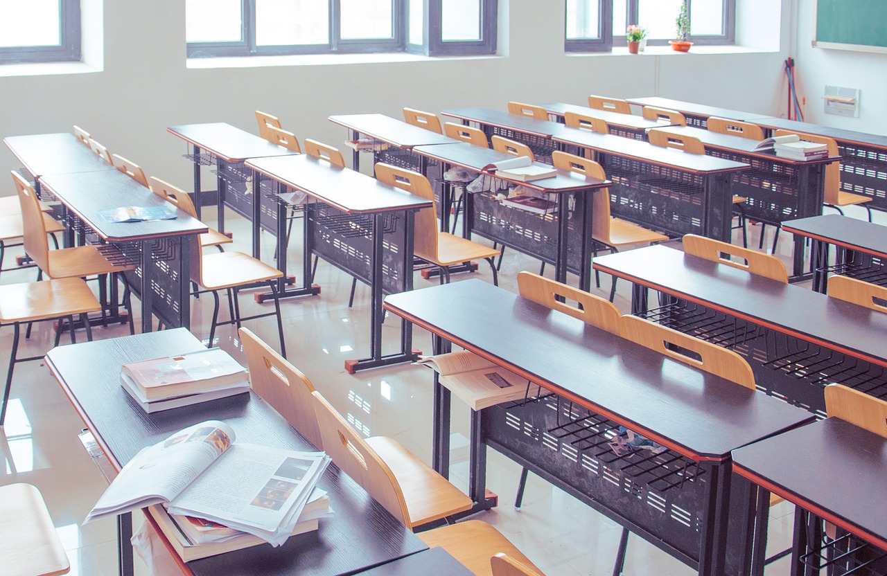 Empty classroom with tables and benches