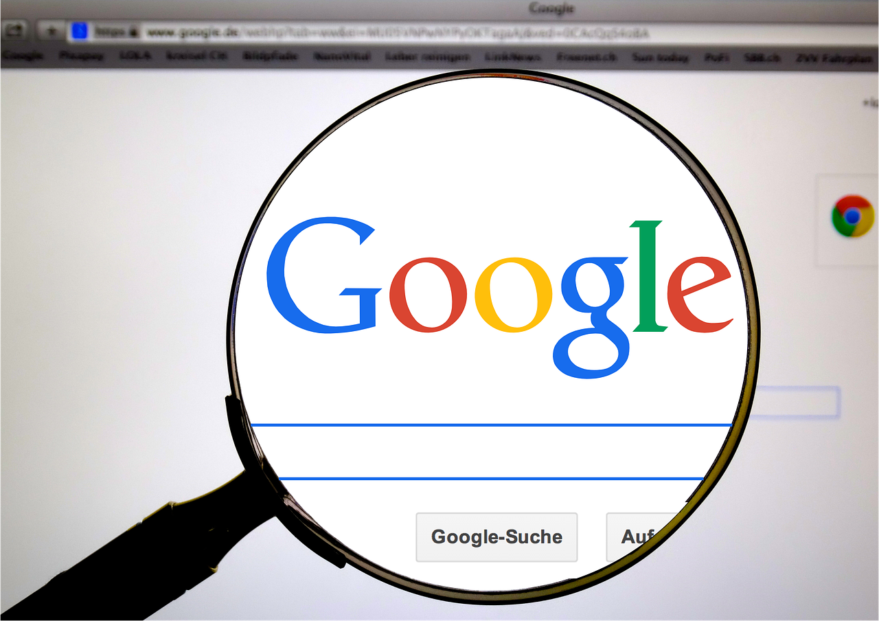 Google's logo under a magnifying glass - relates to  How Google Makes Money! Google's Staggering $80.5 billion Revenue i