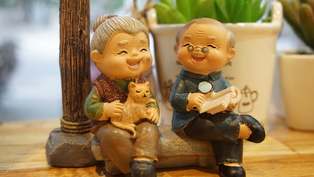 Clay models of a grandmother with a cat on her lap and grandfather with a book