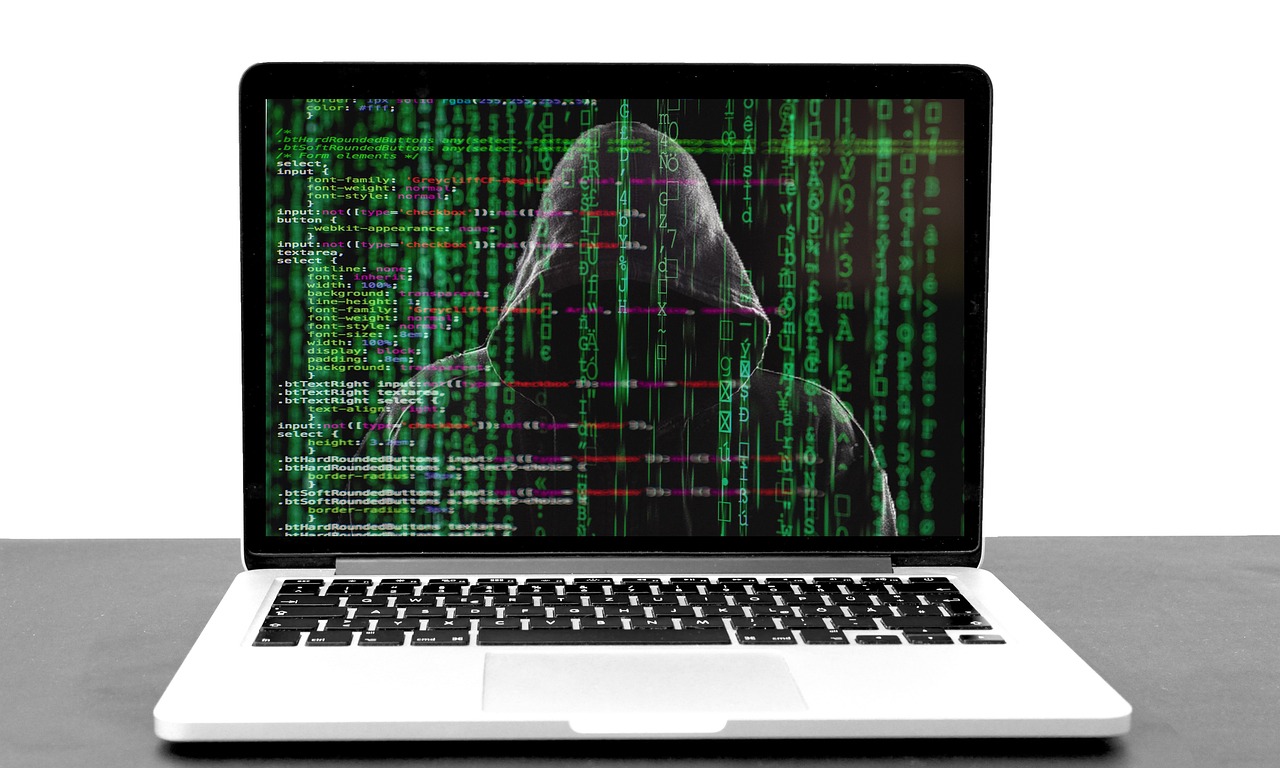 a laptop screen with image of a hacker to highlight digital scams