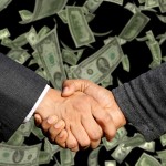 Men shaking hands with moeny in the background