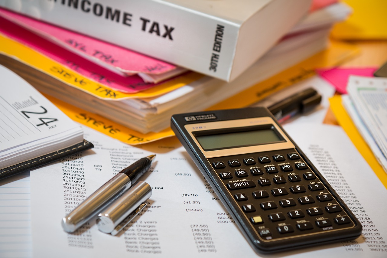 Income tax form with a calculator, pen and a book in Income Tax