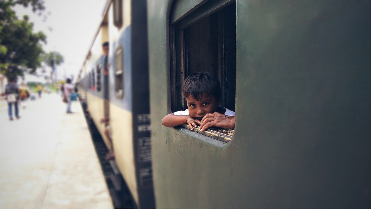 Boy sitting near train's Window seat - relates to How Indian Railways are Changing for a Profit Drive? What it Means