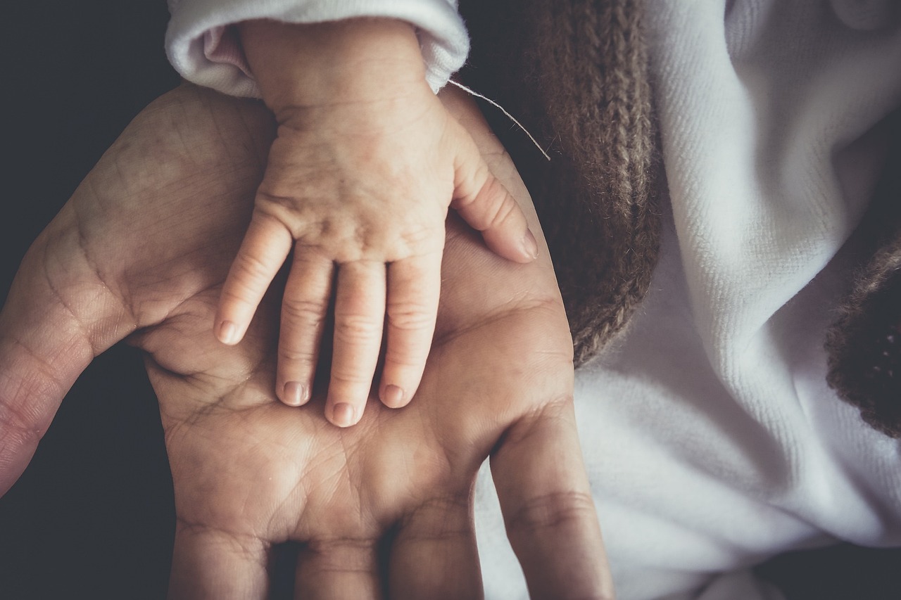 child's hand on adult hand