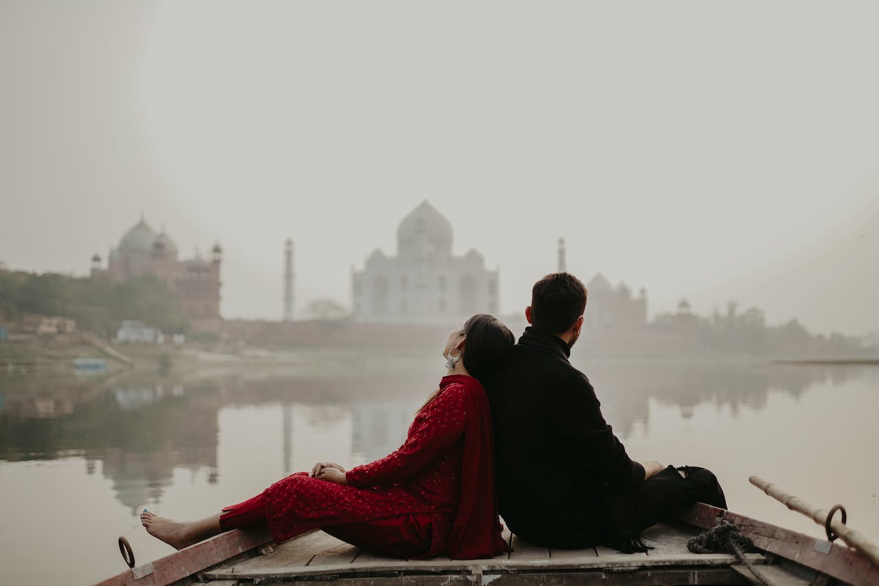 Couple sitting in a boat with Taj Mahal background -image tries to explain benefits of Filing ITR with your Life Partner