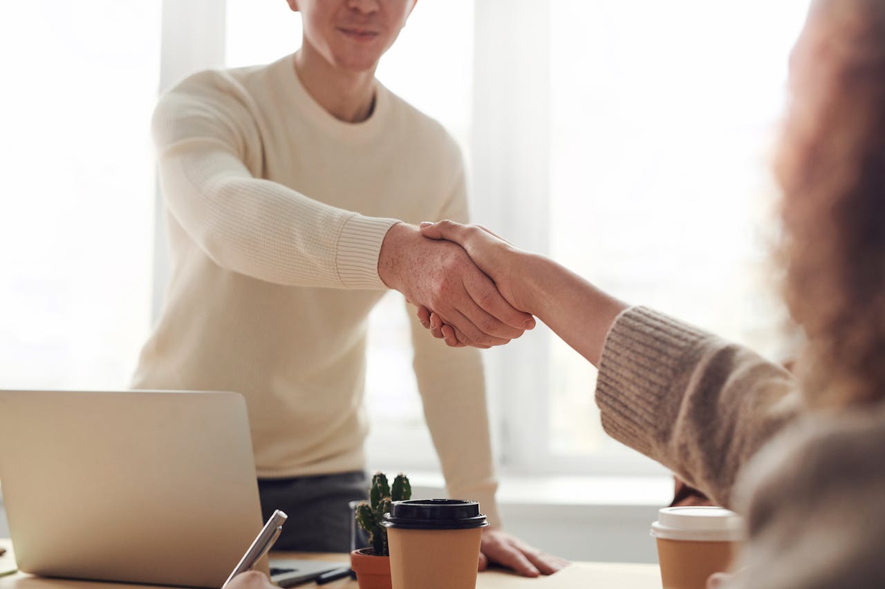 formal handshake between employer & employee – the image tries to explain the secrets to landing your dream consulting j