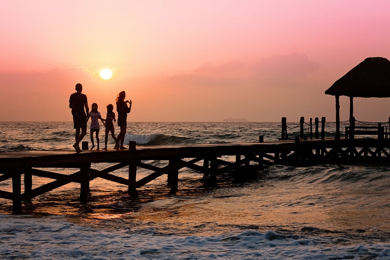 Family standing on dock during sunrise - relates to Why Flexibility & Adaptability are Key to Securing Retirement Plans
