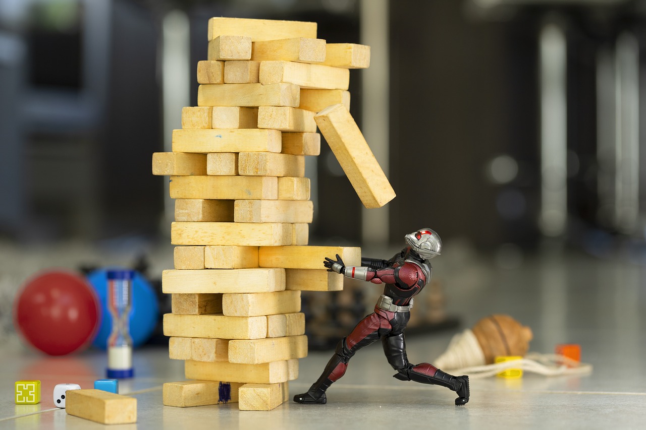 jenga game collapsing and an action figure - relates to China's Economic Slowdown: A Cautionary Tale for India's Growth